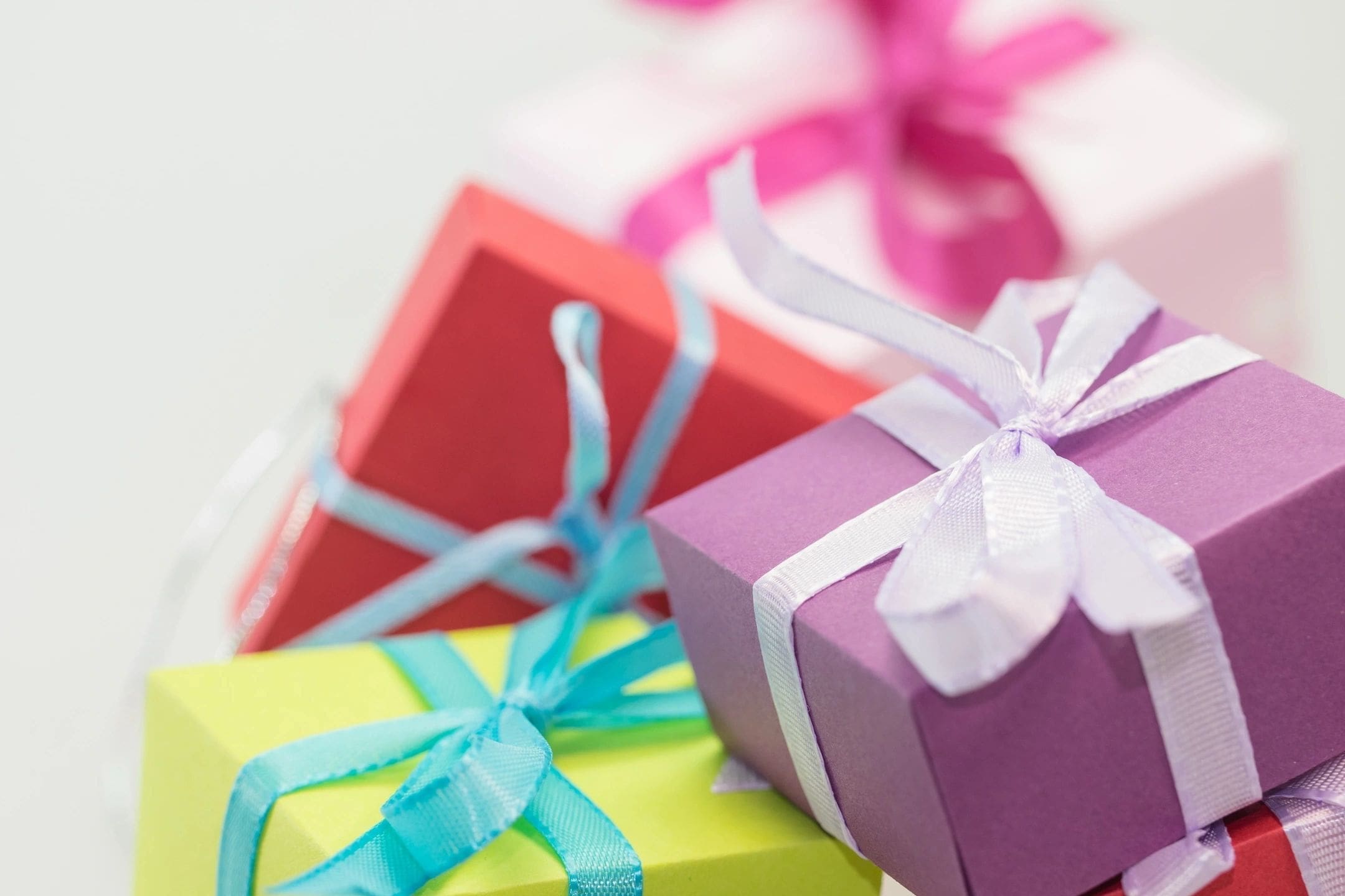 A close up of three different colored gift boxes