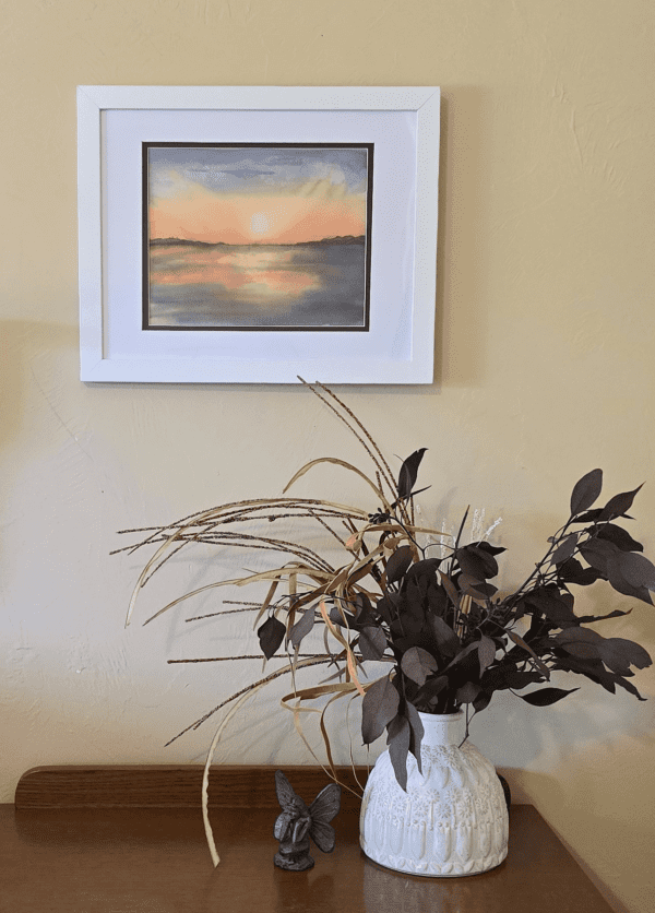 A painting of the sunset in front of a window.