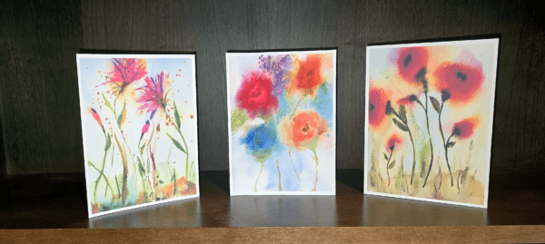 Three cards with flowers painted on them