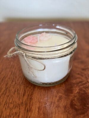 Candle in a jar with decorative flowers.